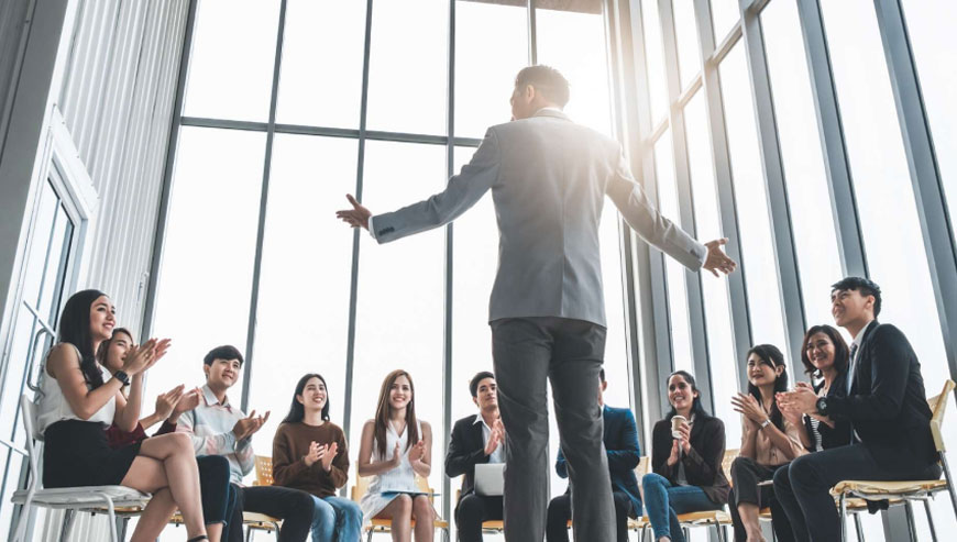 A businessman delivering a speech to an audience, discussing global publishing solutions and sharing industry insights.
