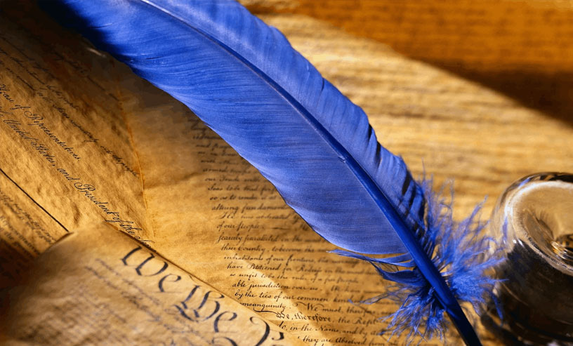 A vibrant blue feather placed on a song writing book, symbolizing artistic expression and the beauty of written words.